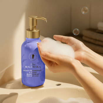Fioletowe mydło w płynie Pani Walewska BLANCHE RELAX z pompką, dłonie z kremową pianą nad umywalką.
