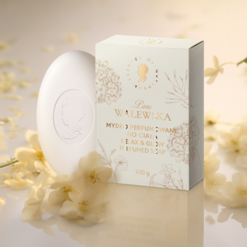 Pani Walewska RELAX & GLOW mydło perfumowane. Biała owalna kostka i złoto-białe pudełko z floralnym wzorem, w otoczeniu kwiatów.