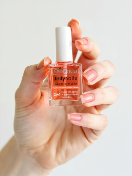 Bielenda Jellynails Laker Odżywka 2w1 z efektem żelu, przezroczysta butelka, trzymana w dłoni na jasnym tle.