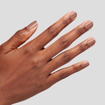 Dłoń o ciemnej karnacji z paznokciami pokrytymi lśniącym, półprzezroczystym, brzoskwiniowym lakierem Mirror, Mirror on the Awe.