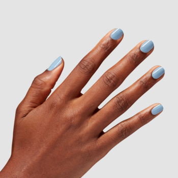 Zbliżenie: Dłoń z ciemniejszą karnacją, paznokcie pomalowane błyszczącym turkusowym lakierem Reality Check Ya Out.