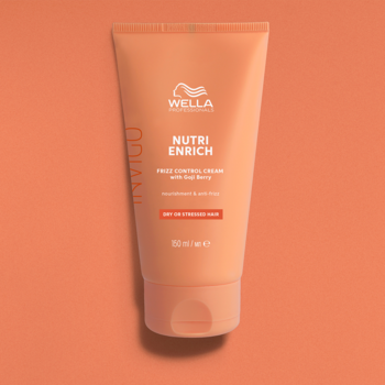 Pomarańczowa tubka kremu Wella Invigo Nutri-Enrich Frizz Control, widok z przodu, na brzoskwiniowym tle.