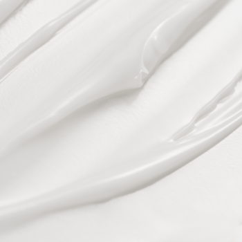 Zbliżenie na białe, kremowe serum z bakuchiolem, ukazujące jego gęstą, nawilżającą formułę.