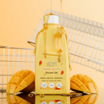 Żółty żel pod prysznic Fluff Mango Gelato, butelka z ociekającym żelem i świeżymi mango, na pomarańczowym tle.