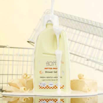 Fluff Butter Milk Żel pod prysznic, żółta butelka, mleczny płyn spływa po opakowaniu, na białym tle z koszykami.
