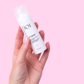 Geek & Gorgeous 101 A-Game 5, białe serum z retinalem w butelce, trzymane w dłoni na różowym tle.