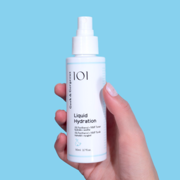 Tonik 101 Liquid Hydration z 5% pantenolem, biała butelka z atomizerem, w dłoni na błękitnym tle.