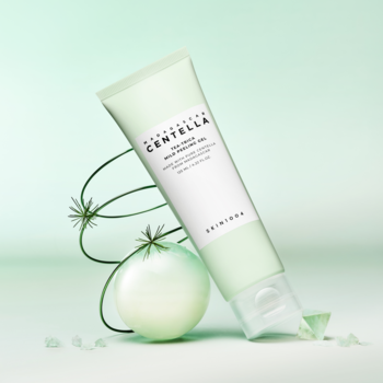 SKIN1004 Tea-Trica Mild Peeling Gel, jasnozielona tubka z żelem złuszczającym, na tle zieleni z roślinnymi dekoracjami.