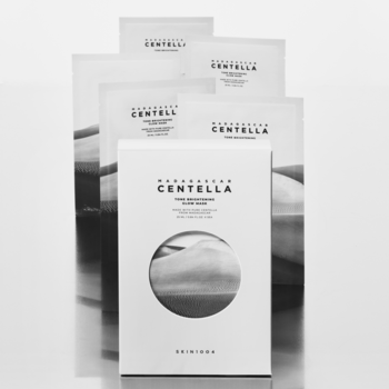 Białe maski w płachcie Skin1004 Madagascar Centella Tone Brightening Glow, ułożone wachlarzowo, z widocznym tekstem i logo.