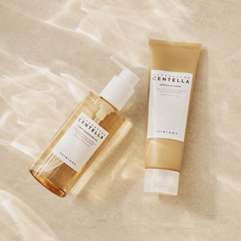 SKIN1004 Madagascar Centella: bursztynowy olejek myjący i beżowa pianka. Widok z góry, na jasnym tle z refleksami.