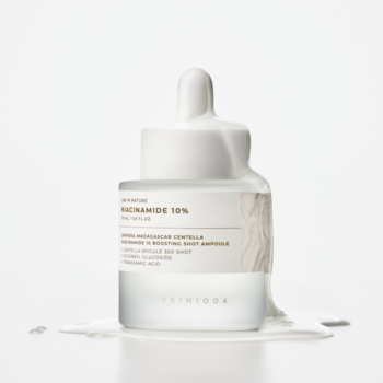 SKIN1004 Niacinamide 10 Boosting Shot Ampoule, matowa butelka z pipetą, biały płyn spływa z korka.