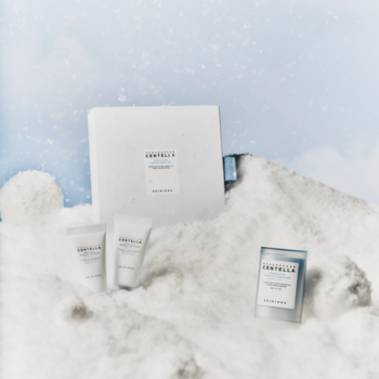 Hyalu-Cica Sunsational Kit: zestaw kosmetyków SPF (serum, sztyft) w białych opakowaniach na puchatym śniegu.