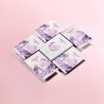 SKIN1004 Madagascar Centella Poremizing Clarifying Mask: białe pudełko i 6 fioletowych masek, na różowym tle.