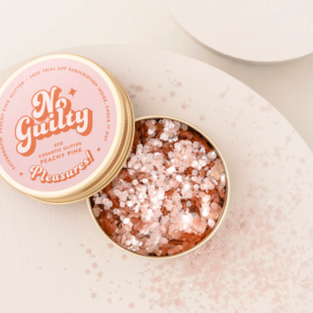 Ministerstwo Dobrego Mydła brokatowe piegi Peachy Pink w otwartej złotej puszce, widok z góry na różowe drobinki.