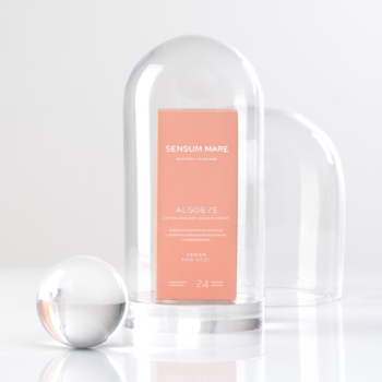 Przeciwzmarszczkowe serum pod oczy Sensum Mare Algoeye w brzoskwiniowym opakowaniu pod szklanym kloszem.