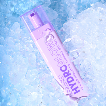 SUNKSSED HYDROGLOW 12H Hydrating Tanning Mousse w fioletowej butelce z pompką, leży na kostkach lodu.