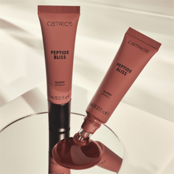 Dwa różowe balsamy Catrice Peptide Bliss Glossy Lip Balm, jeden z błyszczącym produktem wyciśniętym na lustro.