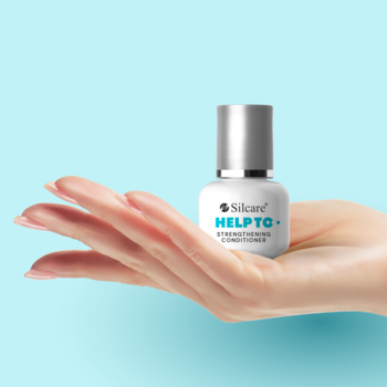 Silcare HELPTQ+ odżywka wzmacniająca paznokcie w białej buteleczce ze srebrną nakrętką, w otwartej dłoni na błękitnym tle.