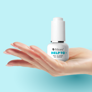 Serum olejowe Silcare HELPTG+ do paznokci i dłoni, biała butelka z zakraplaczem, trzymana w otwartej dłoni, jasnoniebieskie tło.