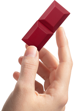 Dłoń trzyma bordową sztabkę perfum Sabrina Carpenter Cherry Baby o geometrycznych segmentach.