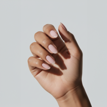 Zbliżenie dłoni z manicure, paznokcie pomalowane lakierem COOLNAILS Blushing Hour w jasnym, naturalnym różu.