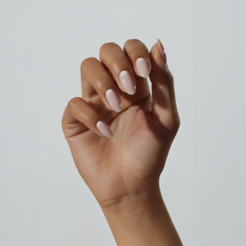 Ręka z paznokciami pomalowanymi odżywką COOLNAILS Marshmallow, dającą naturalny, mlecznoróżowy efekt 'clean'.