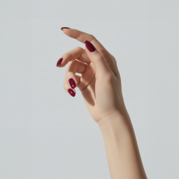 COOLNAILS Lakier Plum Noir 206 na dłoni, z eleganckim winno-bordowym kolorem paznokci, zbliżenie.