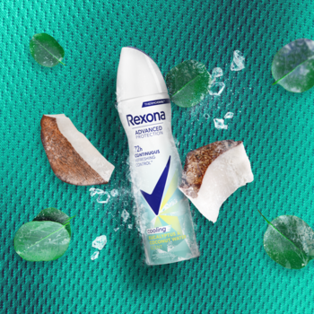 Rexona Advanced Protection Cooling Eucalyptus & Coconut Water antyperspirant w sprayu, otoczony kokosem, liśćmi i lodem na turkusowym tle.