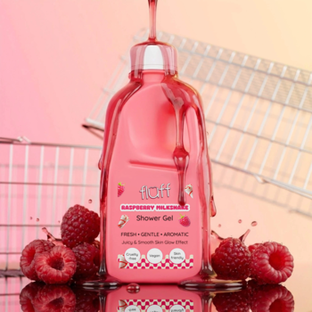 Fluff Raspberry Milkshake żel pod prysznic w różowej butelce, oblany żelem, z malinami na tle koszyka.