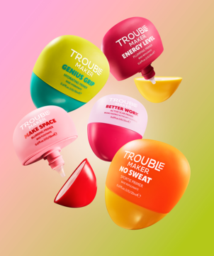 Zestaw pięciu kolorowych baz żelowych Trouble Maker, każda z innym opisem, unoszących się na tle pastelowym.