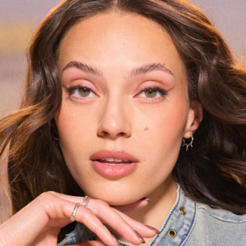 Zbliżenie na kobietę z brązowymi włosami, subtelnie wykonturowanym spojrzeniem kredką Scultping Stix Maybelline.