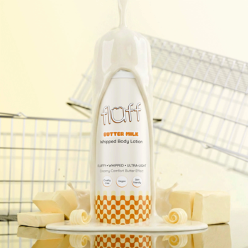 BALSAM DO CIAŁA BUTTER MILK w białej butelce z pomarańczowym wzorem, oblany mlekiem, kostki masła.