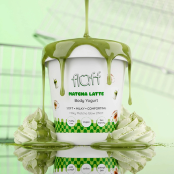 Fluff Matcha Latte Body Yogurt w białym kubku z zielonymi akcentami, polewany gęstą matchą na rozmytym, zielonym tle.