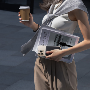 Osoba idąca z telefonem i beżowym powerbankiem Baseus EnerFill FM11 MagSafe 10000 mAh, trzyma też kawę.