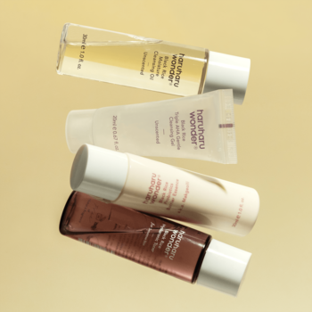 Haruharu Wonder Best Glow Zestaw: 4 kosmetyki Black Rice (olejek, żel, esencja, tonik), ukośnie na żółtym tle.