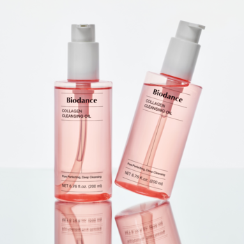 Dwie różowe butelki Biodance Collagen Cleansing Oil, jedna pionowo, druga pochylona, na białym tle.
