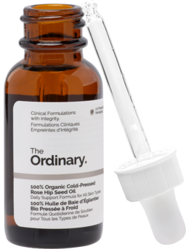The Ordinary 100% Organic Cold-Pressed Rose Hip Seed Oil w bursztynowej butelce z etykietą i pipetą, widok z boku.