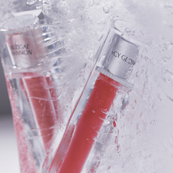 Dwa czerwone błyszczyki Muzigae Mansion Icy Glow Breezy w lodowatej wodzie, zbliżenie, napisy na zakrętkach.