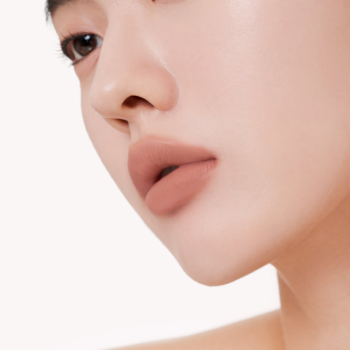 Zbliżenie na usta z lekkim tintem Muzigae Mansion Tension w odcieniu nude, z matowym wykończeniem.