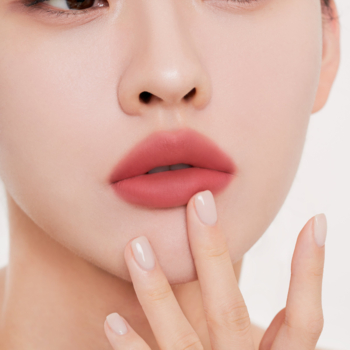 Zbliżenie na usta z matowym tintem Muzigae Mansion After, odcień brudnego różu, palec delikatnie dotyka.