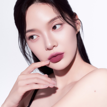 Modelka z matowym tintem Muzigae Mansion Spinel na ustach, widok z bliska, odcień śliwkowego różu.