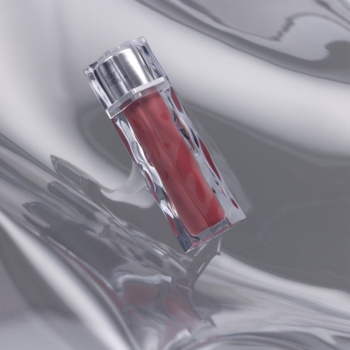 Błyszczyk Muzigae Mansion Icy Glow Chill, skośna butelka z czerwonym płynem na falistym srebrnym tle.