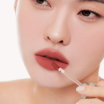 Zbliżenie: Kobieta nakłada lekki tint Muzigae Mansion Sequence na usta, matowe wykończenie, widok na aplikator.