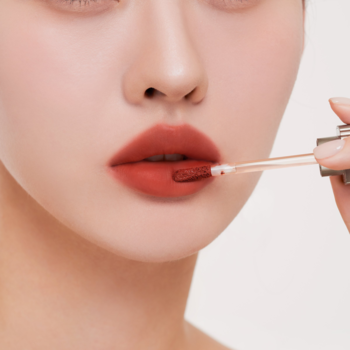 Matowy tint do ust Muzigae Mansion Notable w kolorze terakoty, aplikowany na usta.