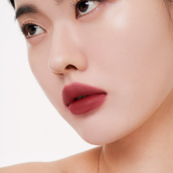 Zbliżenie na usta kobiety z matowym tintem Muzigae Mansion Perception w odcieniu bordowym, gładkie wykończenie.