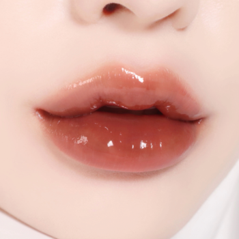 Ujęcie na pełne usta z błyszczącym, brązowym gloss'em. Efekt mokrych ust z gładką i jasną skórą wokół.