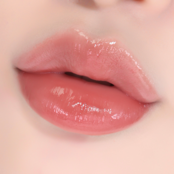 Zbliżenie na usta pokryte błyszczykiem w odcieniu brzoskwiniowego różu, z efektem pełności i wilgoci.