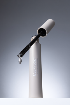 Otwarty utrwalający żel do brwi EVERDOU w jasnej tubce, z aplikatorem i widoczną kroplą żelu.