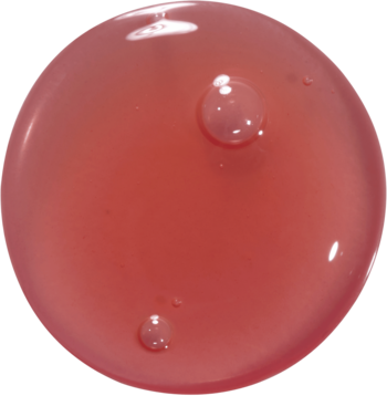 Kropla nawilżającego olejku Kaja Juicy Glass Lip Oil Plum Paloma, czerwono-różowa, transparentna z bąbelkami.