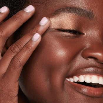 Kaja Beauty Bento Trio cieni Toasted Caramel, kobieta nakłada palcem błyszczący cień na powiekę.